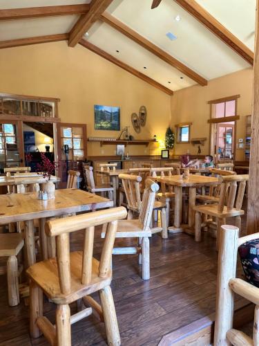 a restaurant with wooden tables and wooden chairs at Chewuch Inn & Cabins in Winthrop