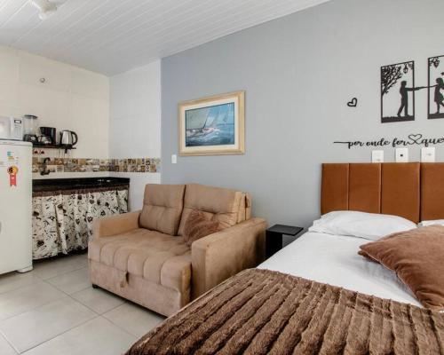 une chambre avec un lit, un canapé et une chaise dans l'établissement Studio 3 - Linda vista beira-mar, à Florianópolis
