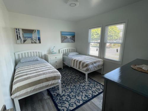 two beds in a room with two windows at Villetta Solare in Belmar