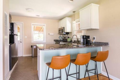 a kitchen with orange chairs at a counter at El Retro- Mid Century Ranch near Horse Park & Rupp in Lexington