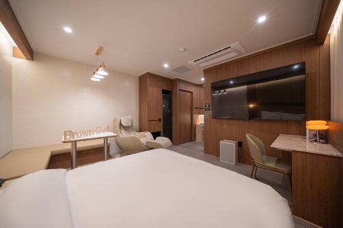a hotel room with a bed and a flat screen tv at Brown Dot Hotel Sangju in Sangju