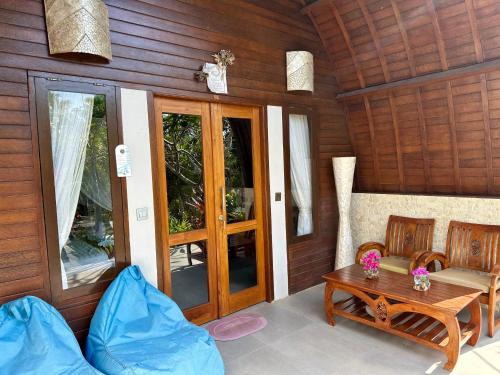 a living room with a table and chairs in a room at Jungle Paradise in Nusa Penida