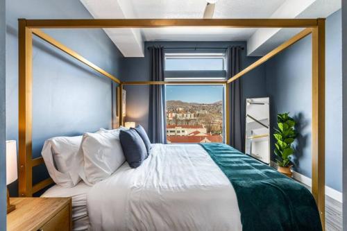 a bedroom with a large bed with a window at Penthouse Apt - PoolGymHotTubPkg - View! in Salt Lake City