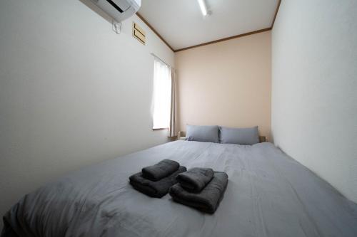 a bedroom with a bed with two towels on it at Lilac in Sapporo