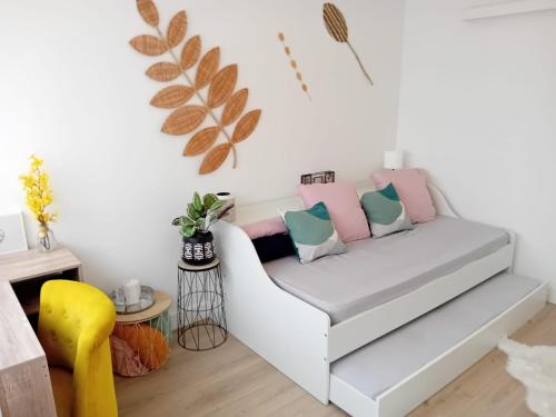 un salon avec un canapé blanc avec des oreillers dans l'établissement Cozy Chic Appart, à Eaubonne