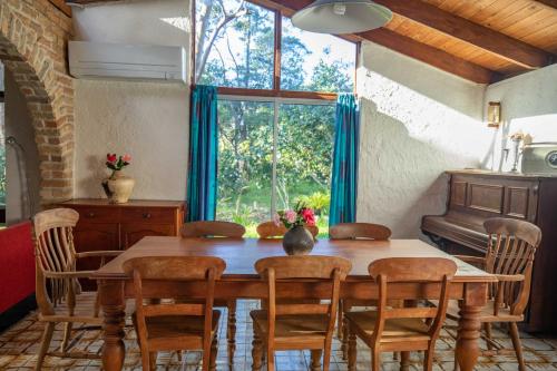 a dining room with a table and chairs and a window at The Bird House in One Mile
