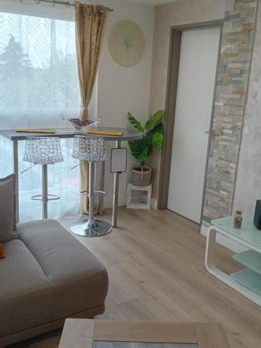 un salon avec un canapé et une table dans l'établissement Cozy Chic Appart, à Eaubonne