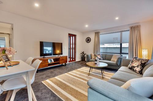 a living room with a couch and a table at Stylish Central City Apartment on Bealey in Christchurch