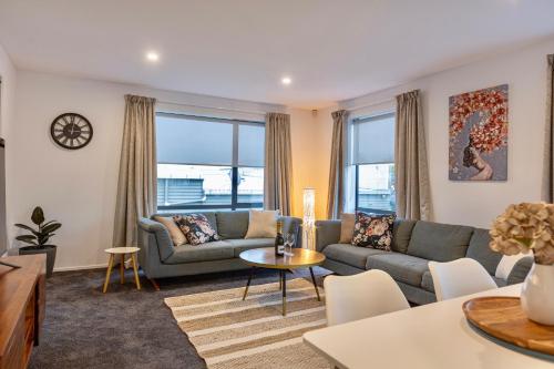 a living room with a couch and a table at Stylish Central City Apartment on Bealey in Christchurch