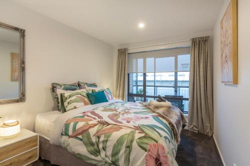 a bedroom with a bed and a window at Stylish Central City Apartment on Bealey in Christchurch