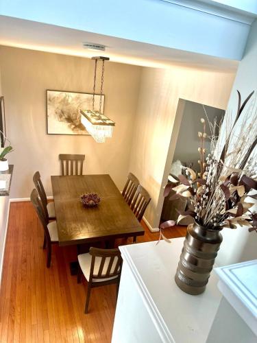 a dining room with a wooden table and a vase with flowers at Modern Home in Sterling in Sterling