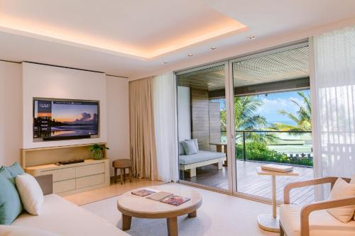 a living room with a couch and a large window at COMO Uma Canggu in Canggu