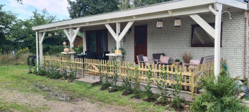 a porch of a house with chairs and a fence at Casa Chill, fijn, vrijstaand chalet bij bos in Anloo