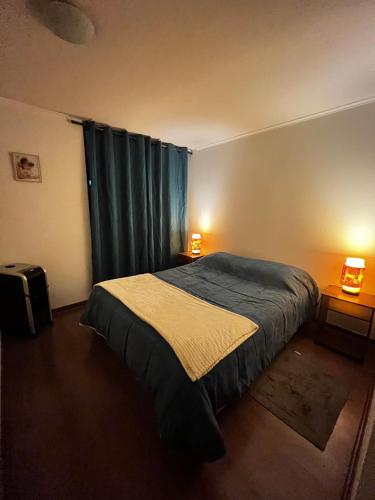 a bedroom with a bed and a window with two lamps at Pauwla in Santiago