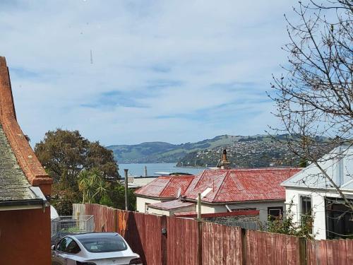 a car is parked in front of a fence at A Stone's Throw From Town Tiny Home in Dunedin