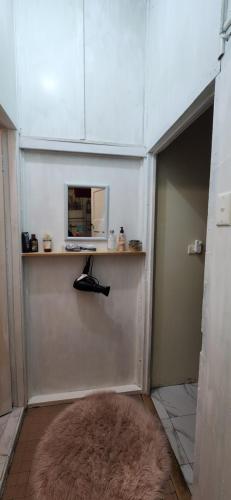 a hallway with a door with a microwave and a rug at Meyenburg Dorm Room in Mount Morgan