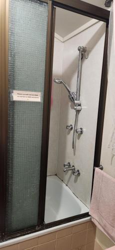 a shower with a glass door in a bathroom at Meyenburg Dorm Room in Mount Morgan