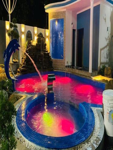 a pool with a fountain with red lights in it at Homestay 8 phòng ngủ Bể bơi riêng- Hà Nội in Ba Vì