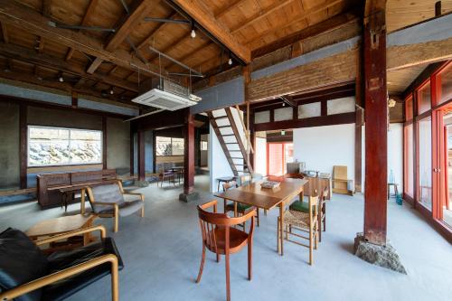 a dining room with a table and chairs and windows at 点景 tenkei in Gamō