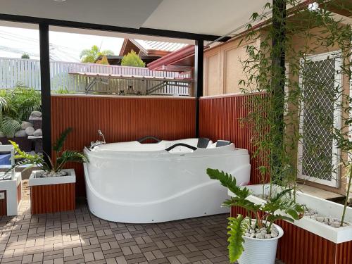 una vasca da bagno seduta su un patio con piante di Davao Rental- Villa Conchita Residential 3Bedroom 2 Bathroom, Gazebo with Jacuzi a Davao