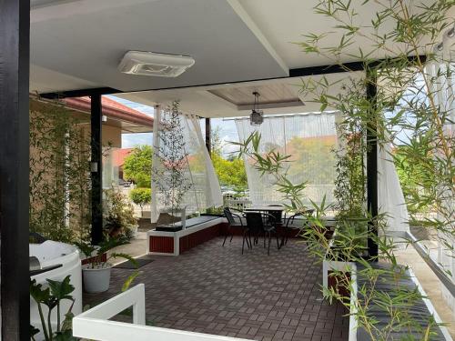 un patio con tavolo, sedie e piante di Davao Rental- Villa Conchita Residential 3Bedroom 2 Bathroom, Gazebo with Jacuzi a Davao
