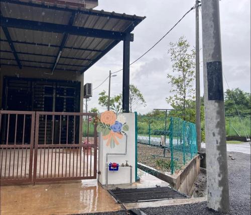 a refrigerator with a painting on it in front of a building at Barakah Homestay Taman Belimbing in Jitra