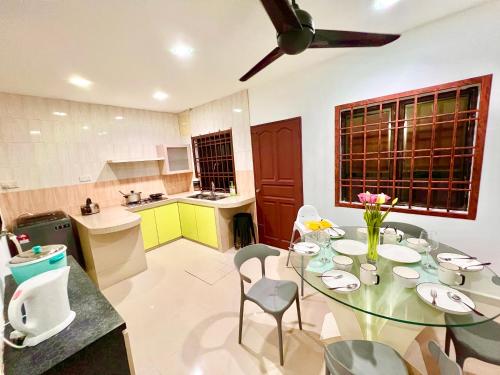 una cucina con tavolo in vetro e sedie in camera di Teddy House with Kids Corner at Bukit Indah Near Legoland and EcoBotanic a Johor Bahru