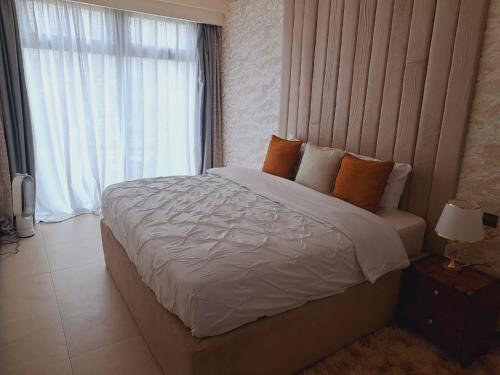 a bedroom with a large bed and a window at Contemporary apartment at Lemac in Nairobi
