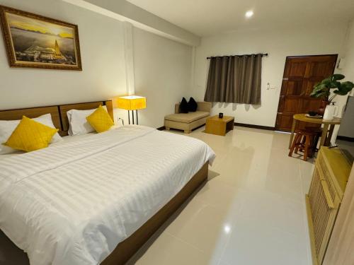a bedroom with a large white bed with yellow pillows at Cuckoo's Nest Ao Nang in Ban Khlong Son