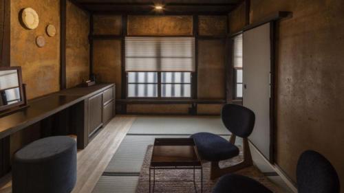 a living room with two chairs and a table at NIPPONIA HOTEL Ozu Castle Town in Ōzu