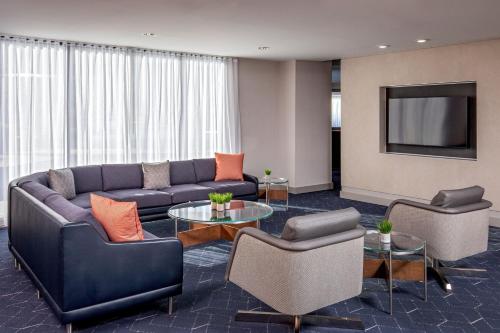 a living room with a couch and chairs and a tv at Courtyard Boston Marlborough in Marlborough