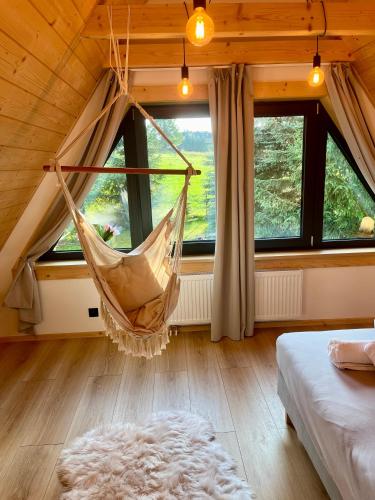 a hammock hanging in a room with windows at Miło Zakopane in Zakopane