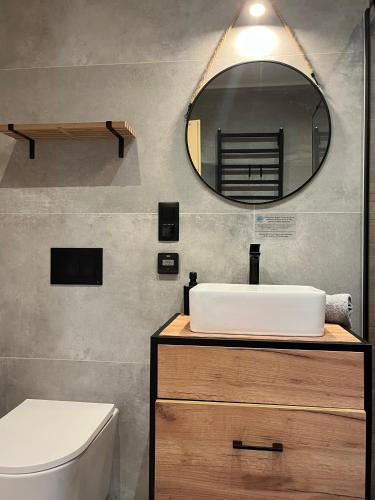 a bathroom with a white sink and a mirror at Miło Zakopane in Zakopane