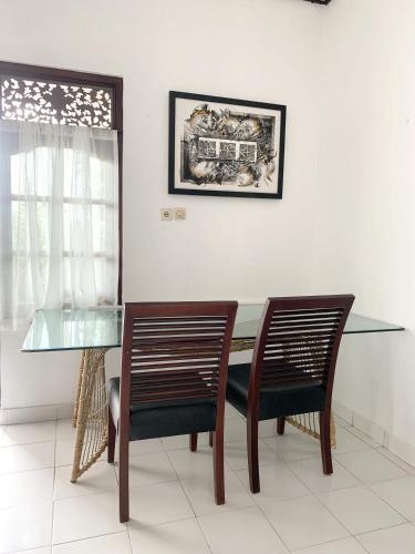 a dining room with a glass table and two chairs at L'ORANGE BUDGET ROOM in Gianyar