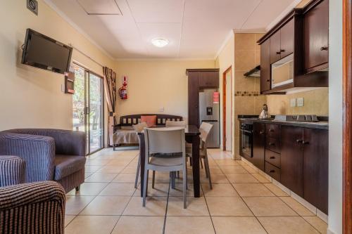 a kitchen and living room with a table and chairs at ATKV Buffelspoort in Rustenburg