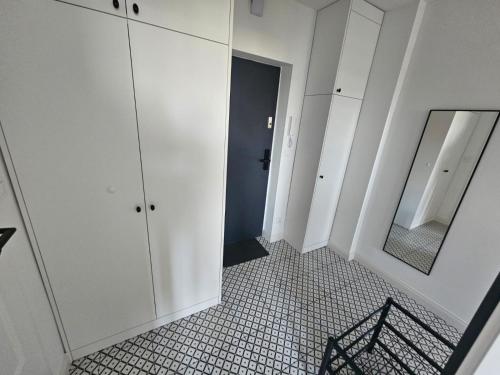 baño con armarios blancos y espejo en TG Loft Apartments, en Tarnowskie Góry