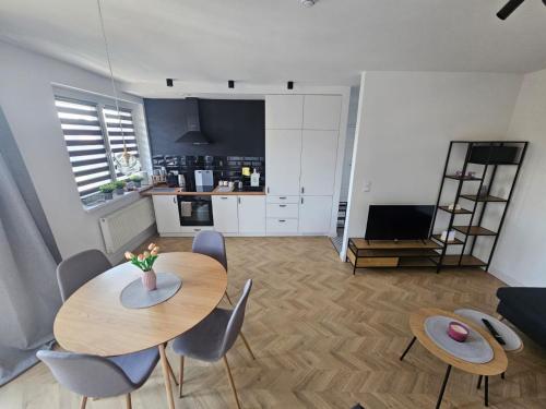 sala de estar con 2 mesas y sillas y cocina en TG Loft Apartments, en Tarnowskie Góry