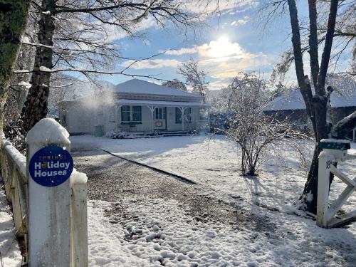a house with a sign on it in the snow at Cheltenham Villa in Hanmer Springs