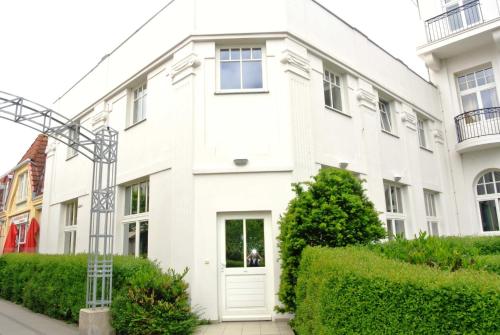 ein weißes Apartmenthaus mit einer weißen Tür in der Unterkunft Haus am Park Whg 02 in Kühlungsborn