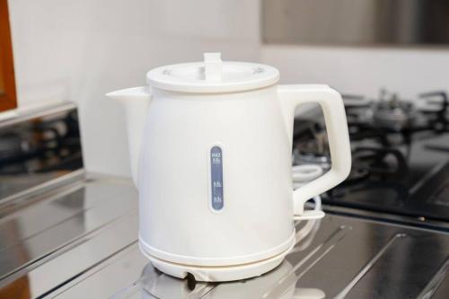 a white electric kettle sitting on top of a stove at 2階 小岩駅徒歩15分 収容4人 成田羽田からバス直通 in Tokyo