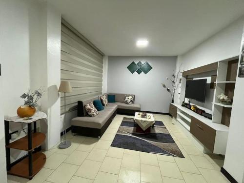 a living room with a couch and a tv at Apartamento Colinas del Pucará in Loja