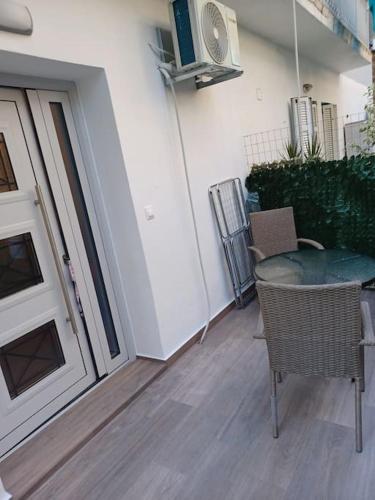 a patio with a table and chairs next to a door at fotinoula1975 in Agios Rokkos
