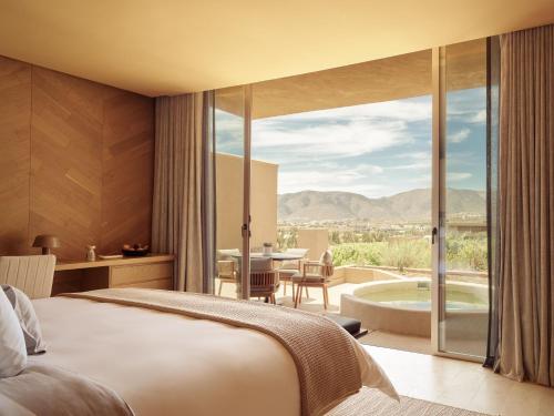 a hotel room with a bed and a view of a tub at Banyan Tree Veya, Valle de Guadalupe - A Wellbeing & Wine Resort in Valle de Guadalupe