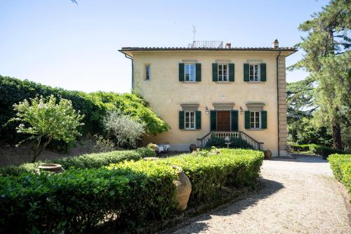 a large house with bushes in front of it at Villa Poggio Bello in Florence