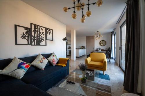 a living room with a blue couch and a yellow chair at Departamento San Miguel- La Luminaria-Confort in San Miguel de Allende