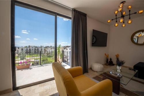 a living room with a couch and a large window at Departamento San Miguel- La Luminaria-Confort in San Miguel de Allende