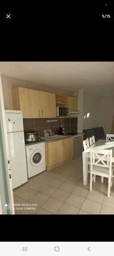 une cuisine avec une machine à laver et une table dans l'établissement Magnifique maison, à Cabriès