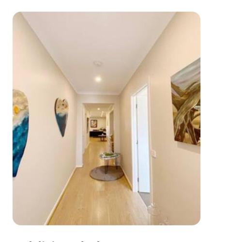 a hallway with paintings on the walls of a house at Blue Breeze in Torquay