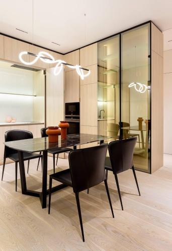 a dining room with a glass table and black chairs at Riverside Cottage Poti in Poti