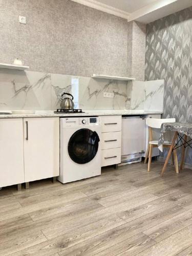 a kitchen with a washing machine and a stove at Riverside Cottage Poti in Poti